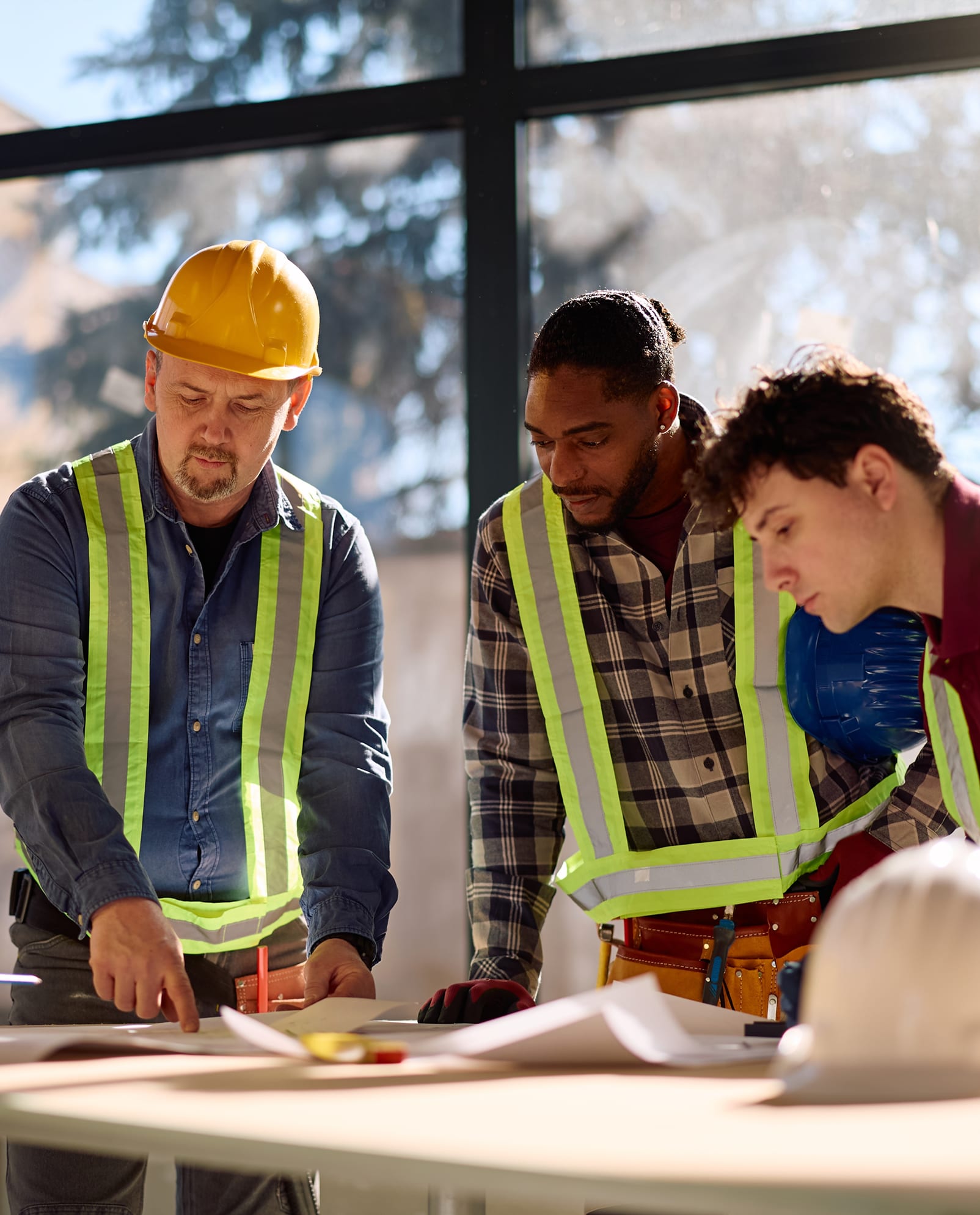 Working professionals collaborating at a table — apartments designed for commuters and busy professionals at Cleve Royale